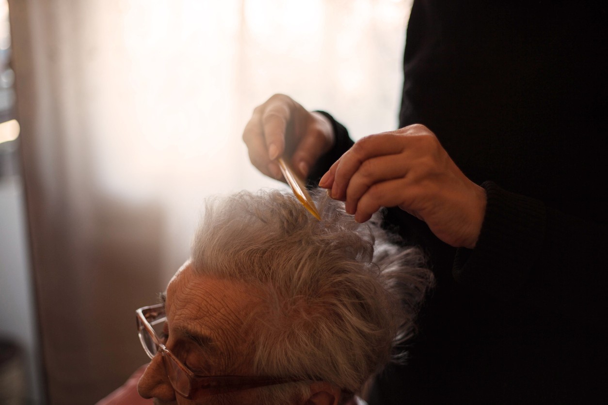 a care worker combing an older woman's hair