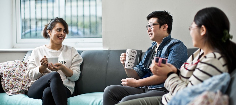 Students chatting with a drink in a social area