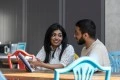 two students sat at a table looking at a guide 