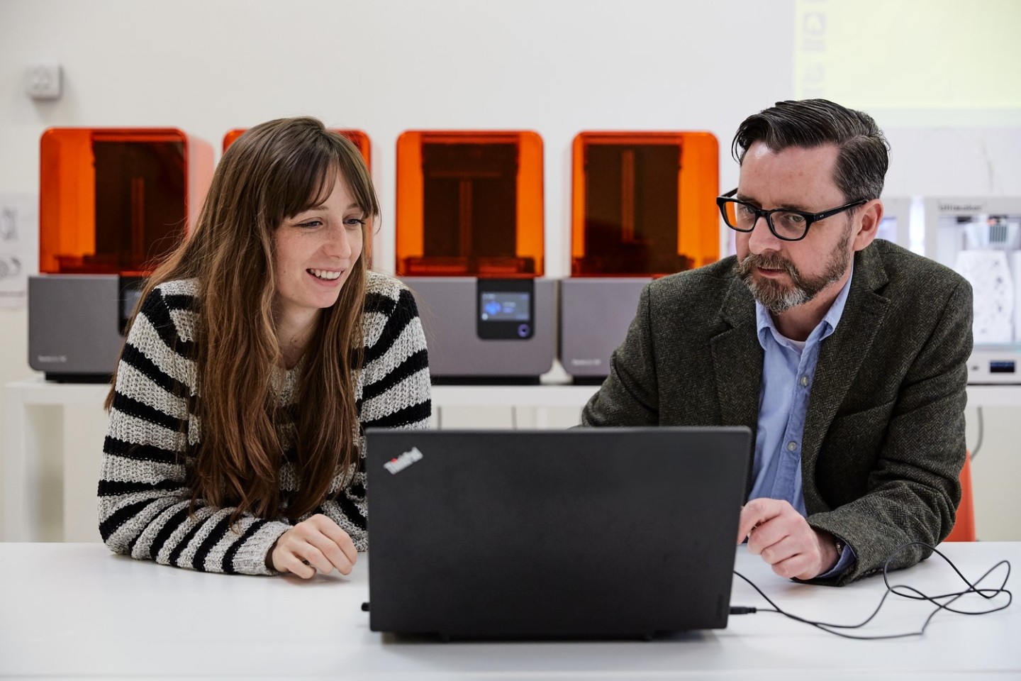 Researcher working at a laptop with a supervisor