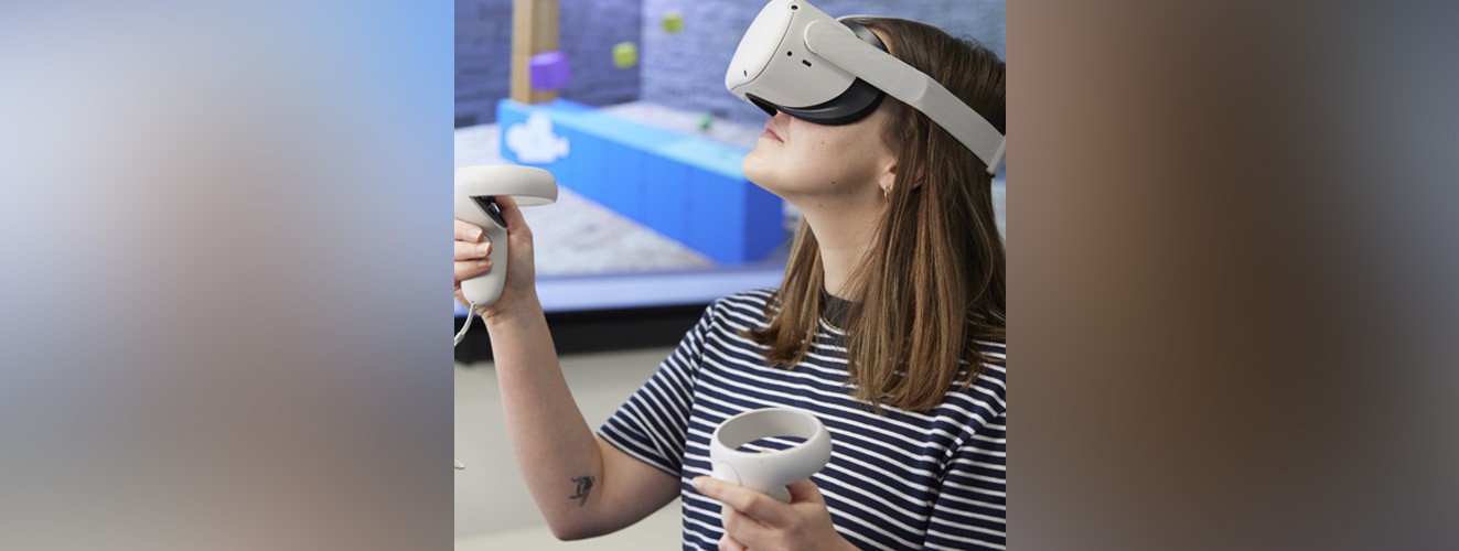 A student is interacting with something in a virtual environment while wearing a VR headset.