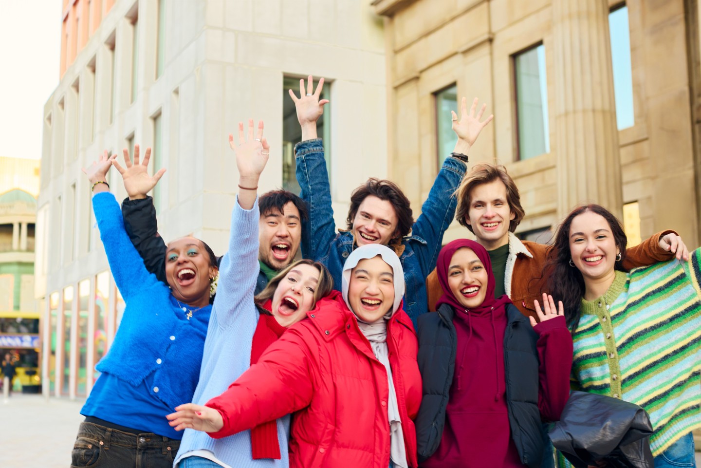 group of students cheering and smiling directly at the camera