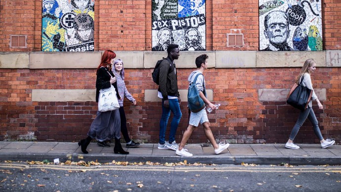 Group of students walking past Aflecks Palace, Manchester