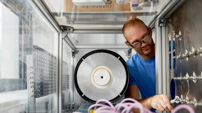 Researcher tightening bolts inside a test chamber