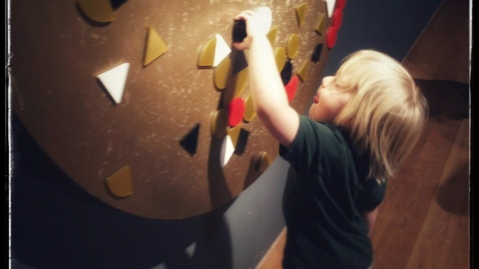 A toddler playing with an interactive learning exhibition