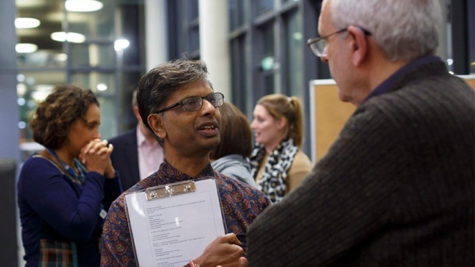 Two ESRI researchers in conversation at a busy research event 
