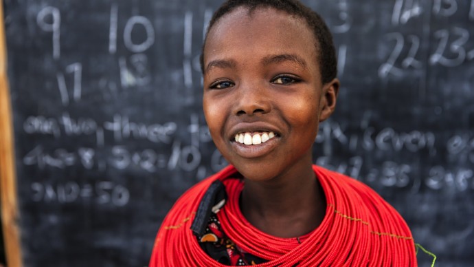 A Kenyan schoolgirl stood in front of a blackboard during a maths class