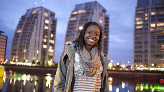 A woman smiling on the quayside at Salford Quays in Manchester, UK