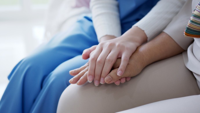 Close up of a patient and healthcare worker holding hands