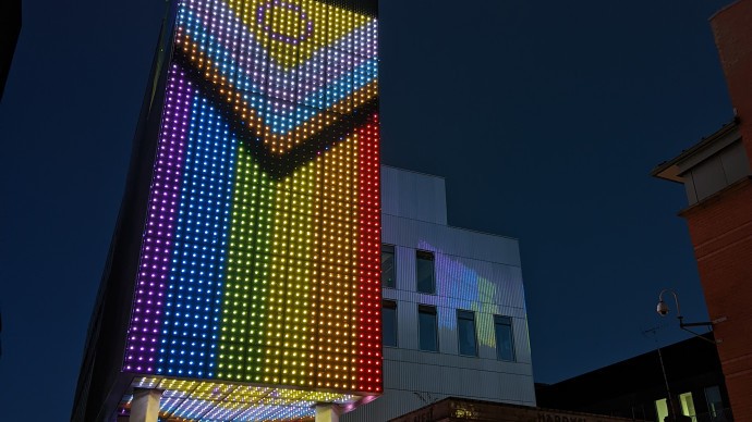 School of Digital Arts lit up with the LGBTQIA+ flag