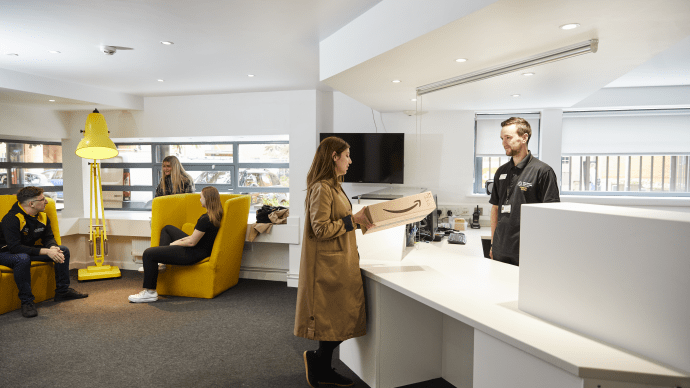 Student collecting parcel from staff member in Cambridge Reception 