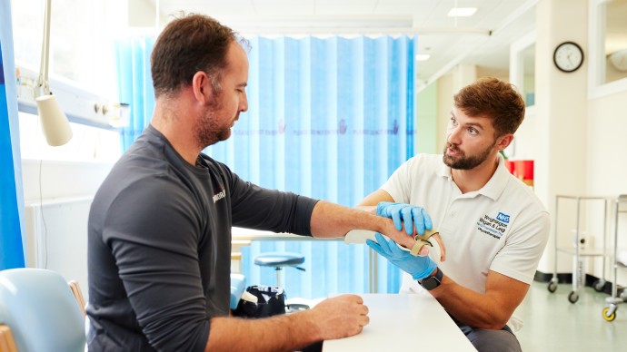 a physiotherapist assessing a man's wrist