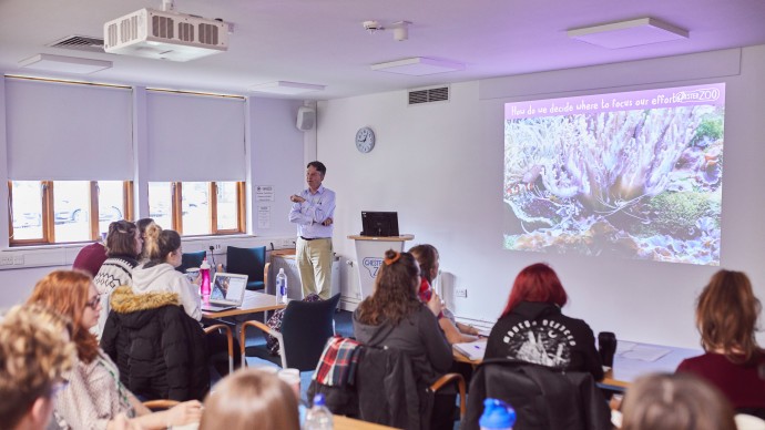 MSc Zoo Consevration Biology students on a field trip to Chester Zoo, sat listening to a tutorial from zoo staff