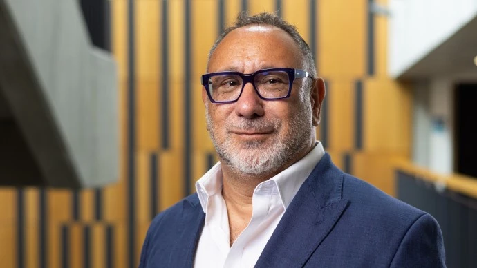 Professor Saul Becker wearing a suit and facing the camera