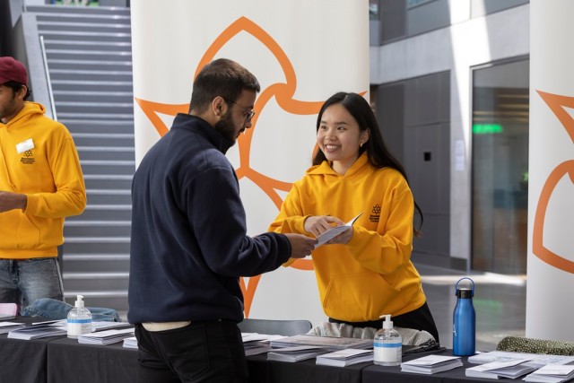 A student working for Jobs4Students, offering help to a student at an event