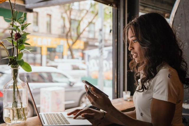 A woman, working on her laptop, sat in a café window