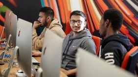 Students at computer hub with mural in background