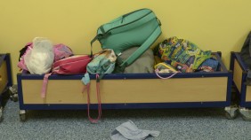 A colourful heap of children's lunch bags in a corridor at school