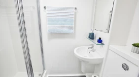 The Archway ensuite bathroom, featuring a shower, sink and mirror. The toilet is not in frame.