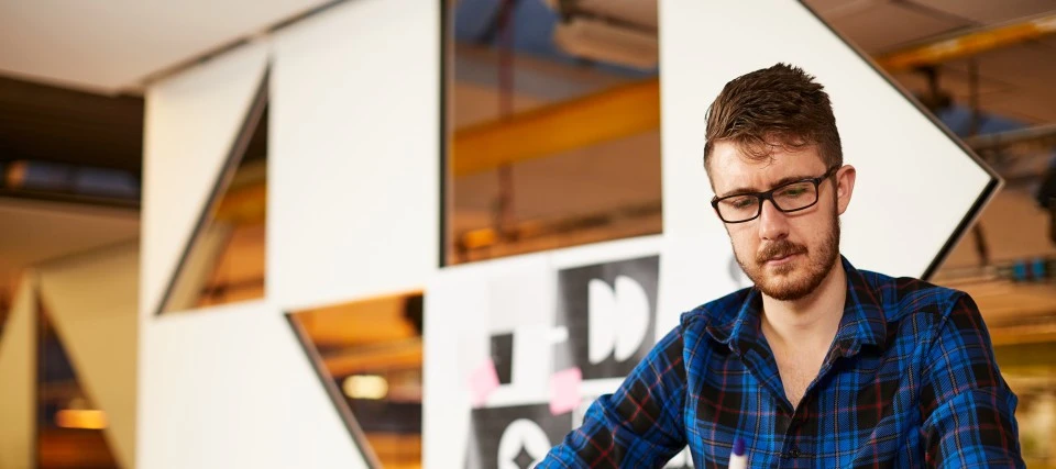 A postgraduate student working on creative designs in a campus studio