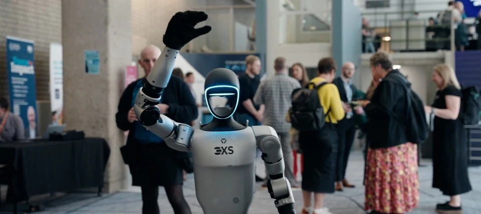 Scan Computers humanoid robot waving to camera at Festival of Innovation exhibition space